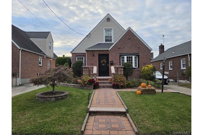 View of front of house with a front yard and brick siding
