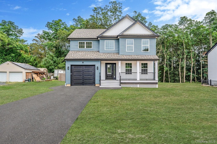 View of front of property featuring roof with shingles, a front lawn, and a porch
