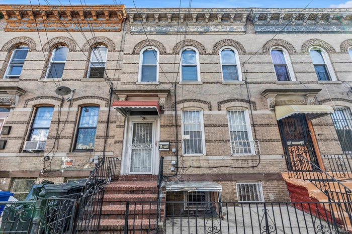 Italianate home featuring brick siding, a gate, and a fenced front yard