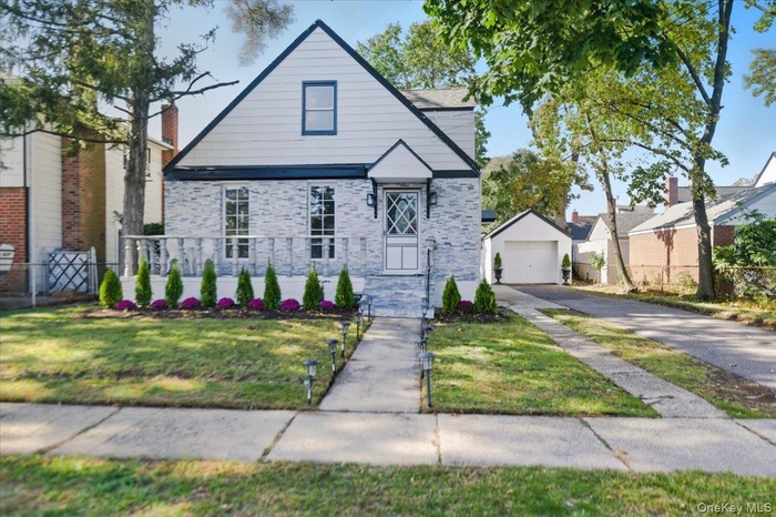 Bungalow-style house featuring asphalt driveway and a garage