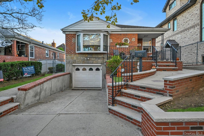 View of front of property with driveway, brick siding, and a garage