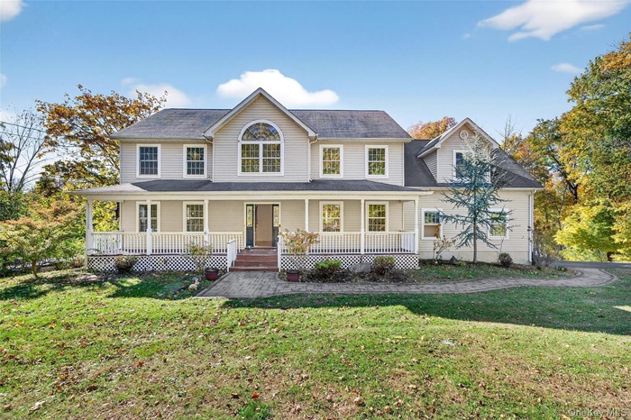 View of front of house featuring covered porch and a front lawn