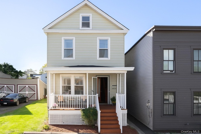 View of front of home featuring covered porch and a front lawn