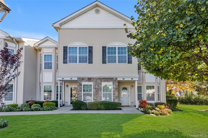View of front of home featuring a front yard and stone siding