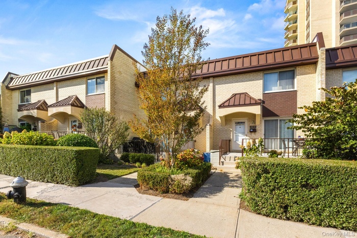 View of front facade featuring brick siding, a standing seam roof, and a metal roof