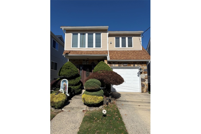 View of front of property featuring an attached garage and driveway