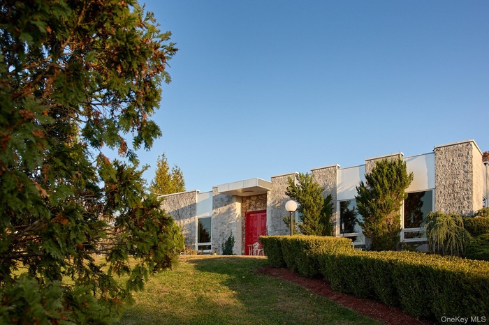 Contemporary house featuring stone siding and a front yard