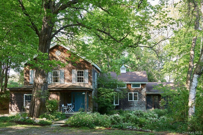 View of front facade with covered porch and a chimney