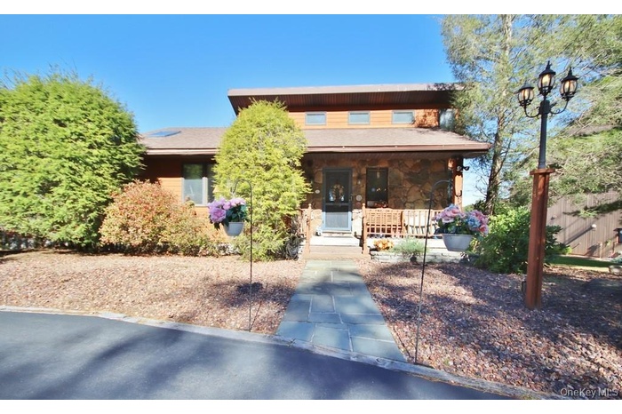 View of front of home featuring covered porch and stone siding