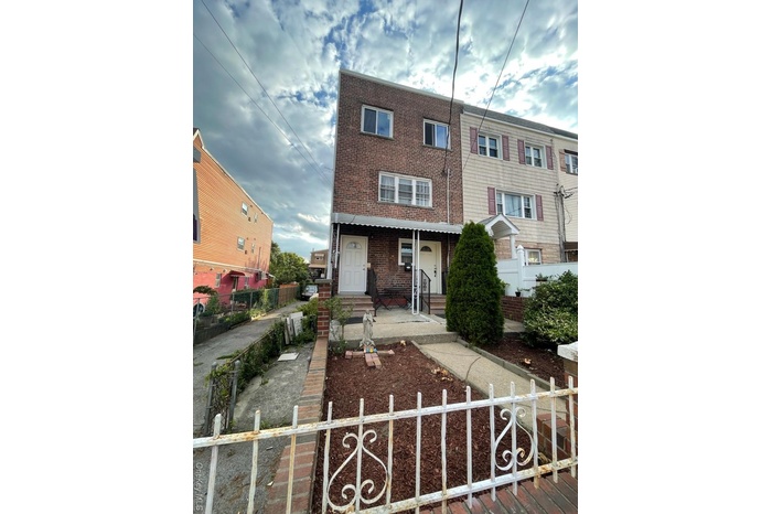 View of front of property with brick siding and a fenced front yard