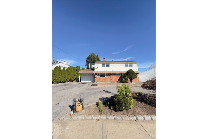 Front of house with large private driveway