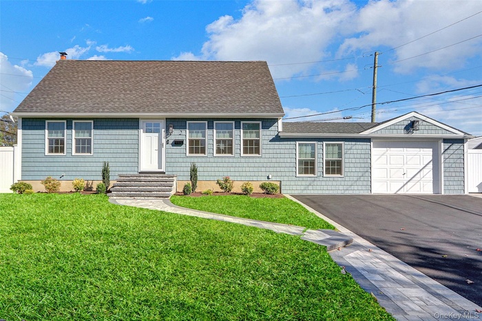 Single story home featuring a shingled roof, driveway, a chimney, and a garage