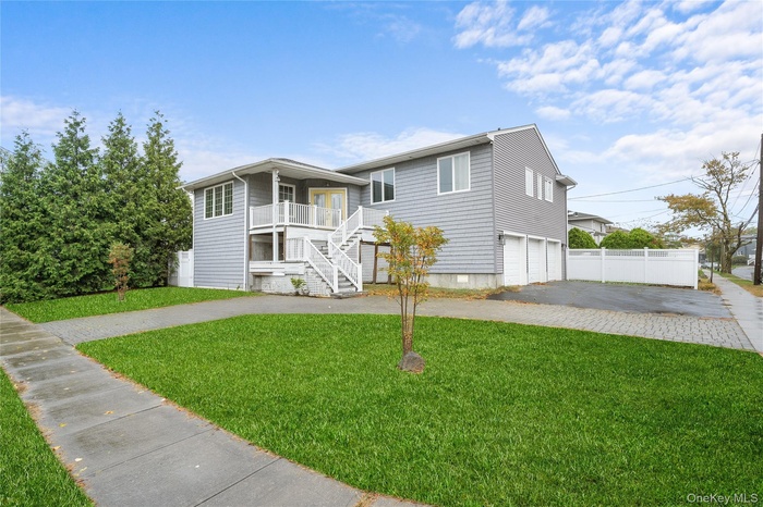 View of front of house with stairs, driveway, and an attached garage