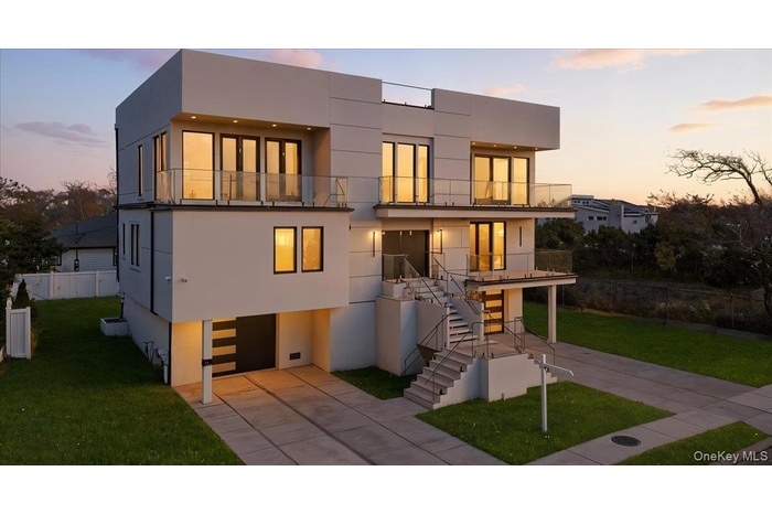 Contemporary house with stairs, a balcony, stucco siding, and concrete driveway