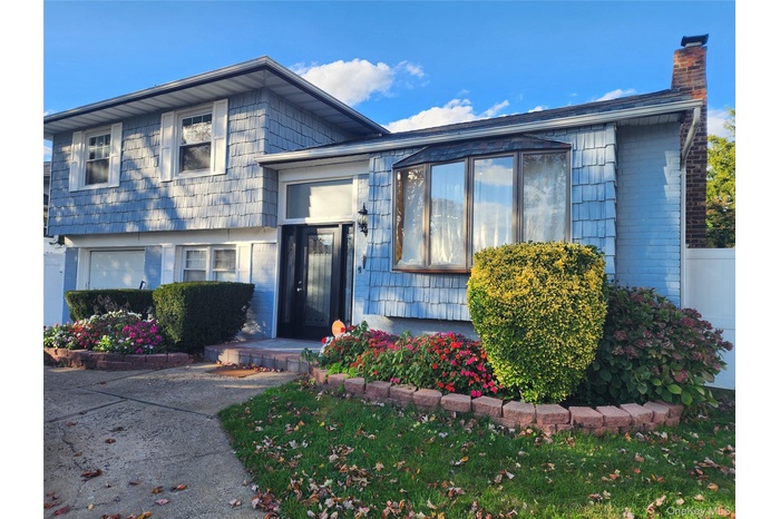 View of front facade with a chimney and brick siding
