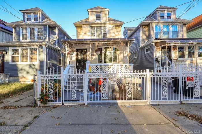 View of front facade with a fenced front yard and a gate