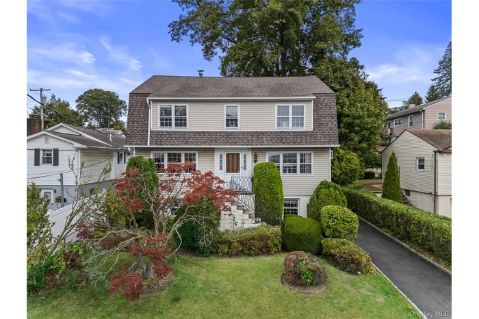 Dutch colonial featuring a shingled roof, a gambrel roof, and a front yard