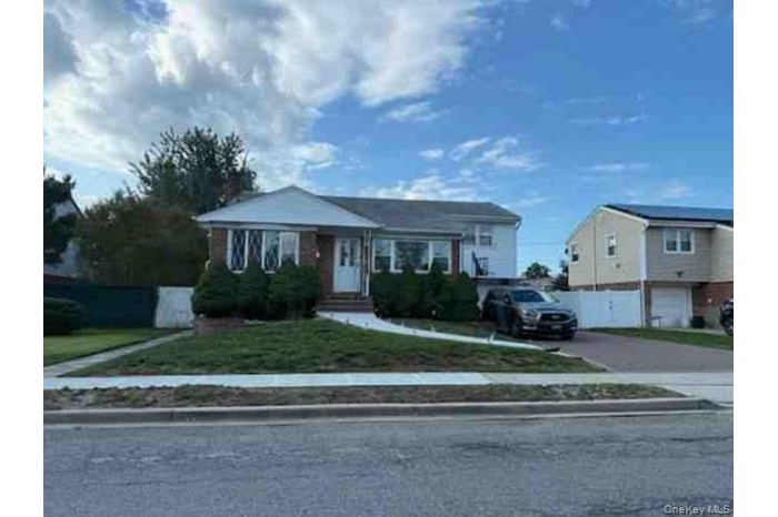 View of front of property with a front lawn and driveway