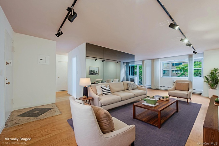 Virtual Staged Living room featuring rail lighting, light wood-style flooring, and baseboard heating