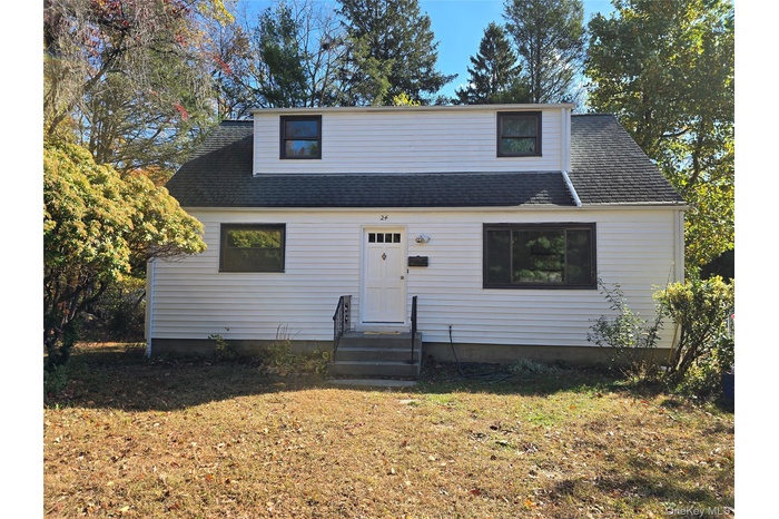 View of front of property with roof with shingles, a front lawn, and entry steps