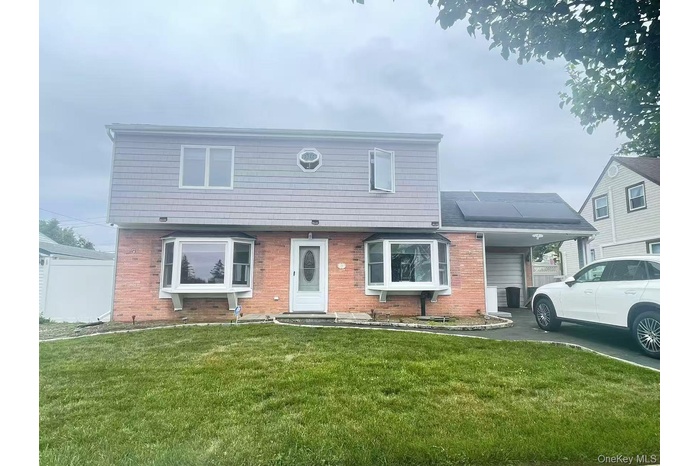 Colonial inspired home featuring a front yard and brick siding