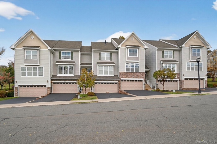 Craftsman-style home featuring stone siding and driveway