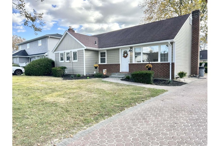 View of front of house featuring a chimney, roof with shingles, and a front yard