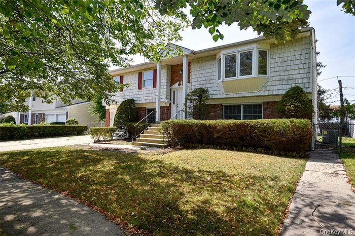 Bi-level home with brick siding and a gate