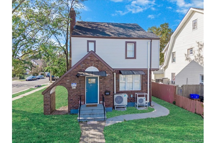 View of front of property featuring a chimney and a shingled roof