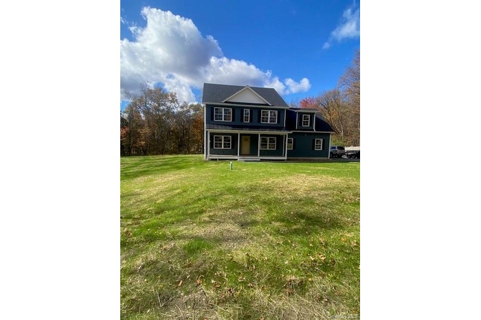 Traditional home with a front yard and a porch
