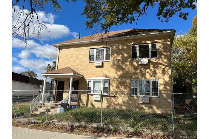 View of front of property with a fenced front yard and brick siding