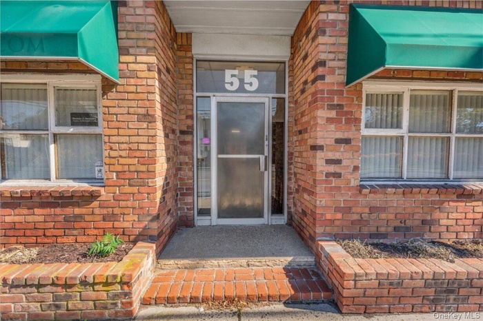 Entrance to property featuring brick siding