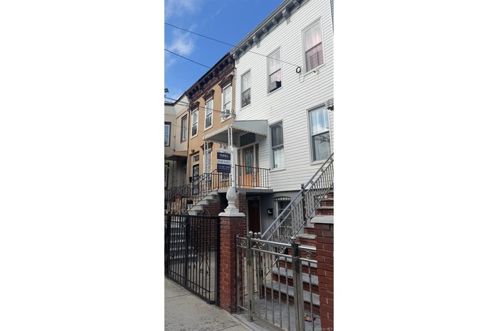Italianate home featuring a balcony, cooling unit, and a gate