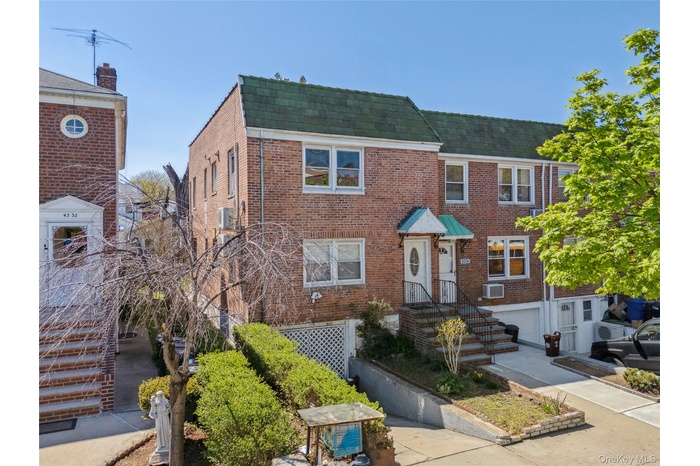 Multi unit property with brick siding, mansard roof, and a shingled roof
