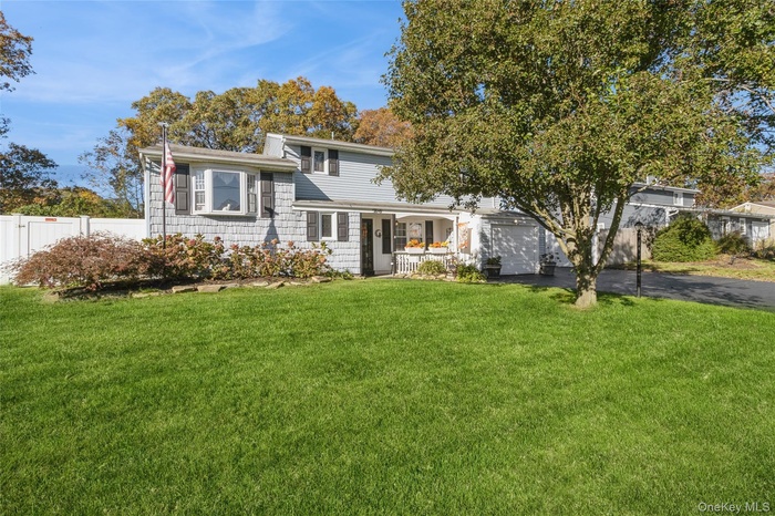 View of front facade with asphalt driveway and an attached garage