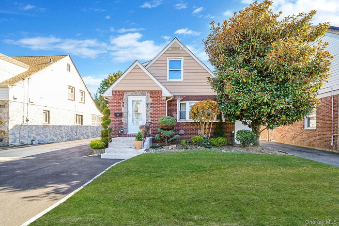 View of front of home with a front lawn and brick siding