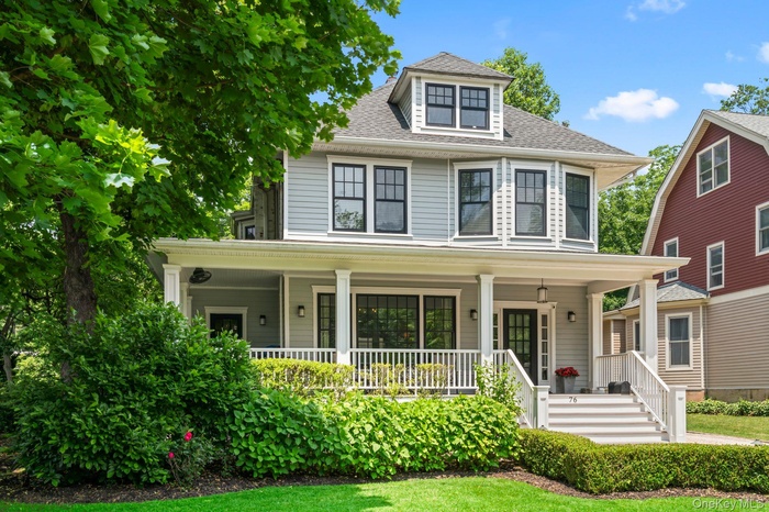 Traditional style home with roof with shingles and covered porch