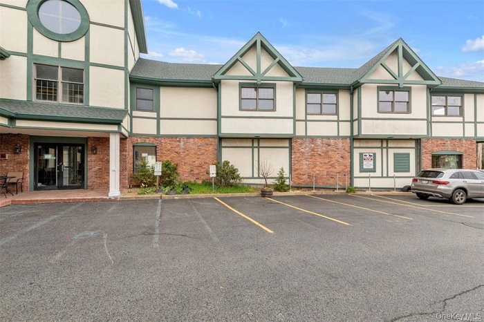 View of building exterior featuring uncovered parking