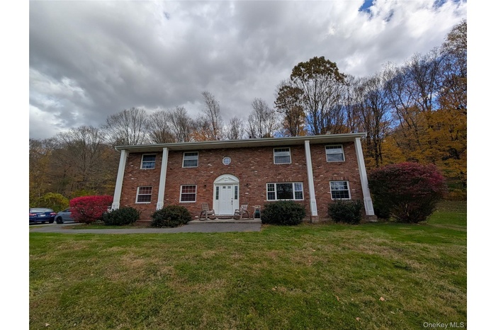 View of front of home featuring brick siding and a front lawn