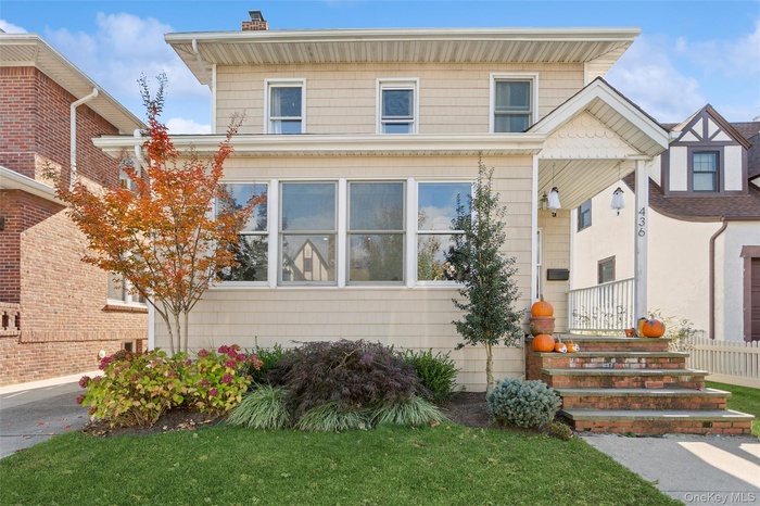 View of front of property featuring a chimney and a front lawn