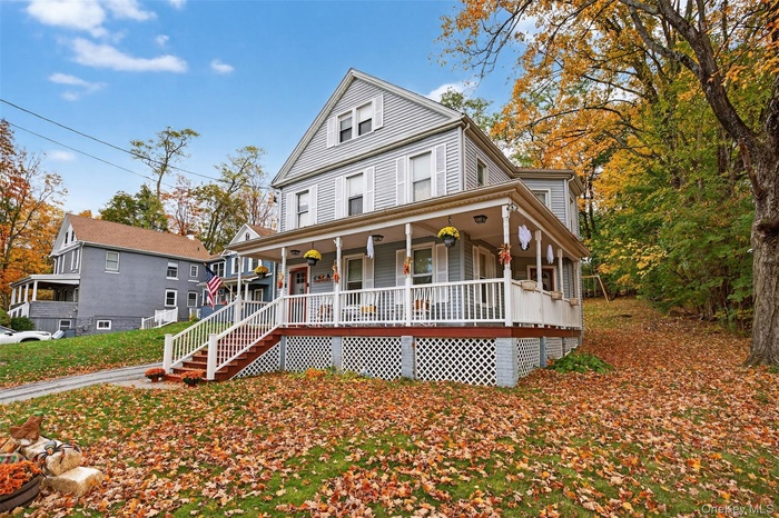 Farmhouse inspired home featuring covered porch and stairway