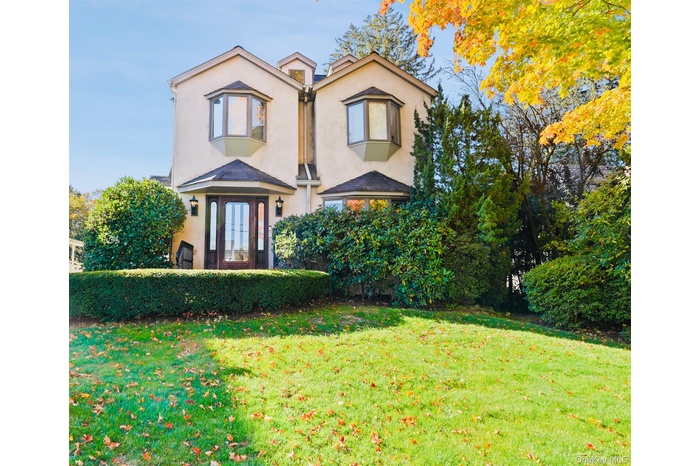View of front facade featuring a front yard and stucco siding