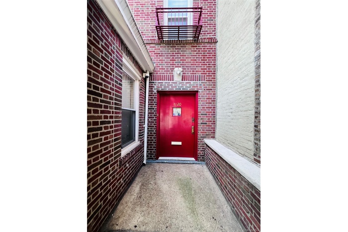 Doorway to property featuring brick siding