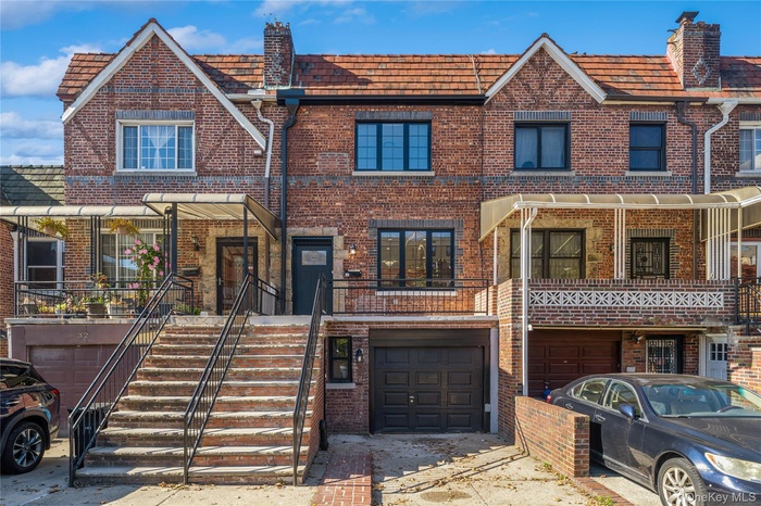 View of front facade with an attached garage and brick siding