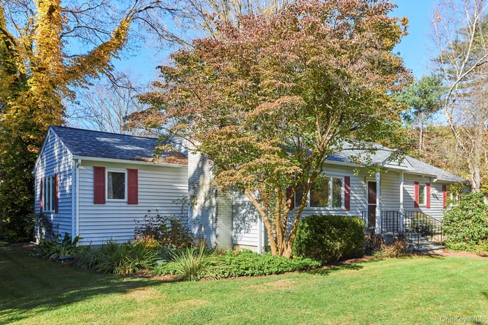 Bungalow with a front lawn and a shingled roof