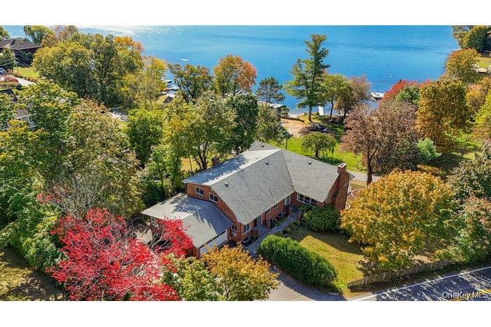 Aerial view of property and surrounding area featuring a nearby body of water