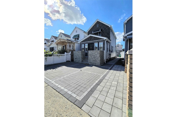 View of front of property featuring a gate and stone siding