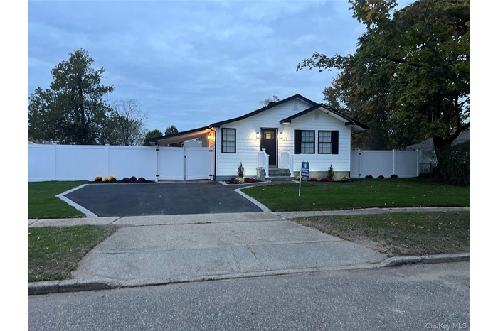 Bungalow-style home with a gate and asphalt driveway