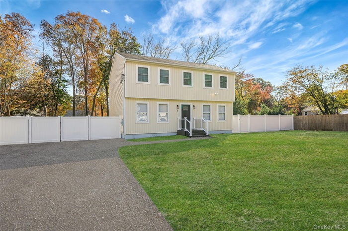 Colonial house with a fenced backyard and a gate