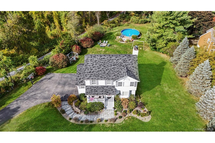 Aerial view of property and surrounding area featuring a pool area